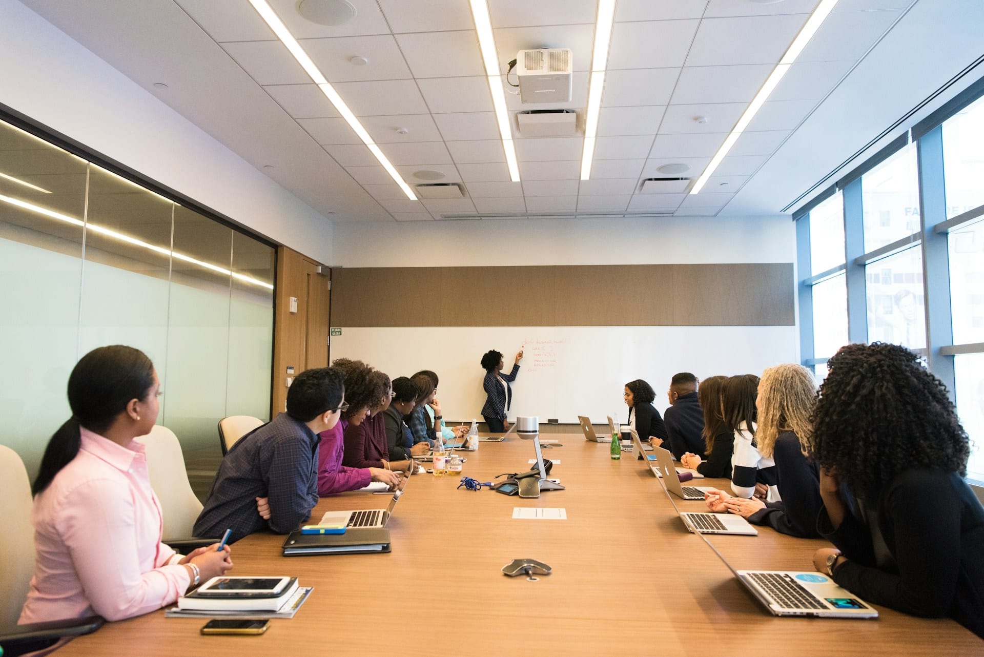 Grupo de fundadores reunidos em volta da mesa de uma sala de reunião, discutindo o negócio.